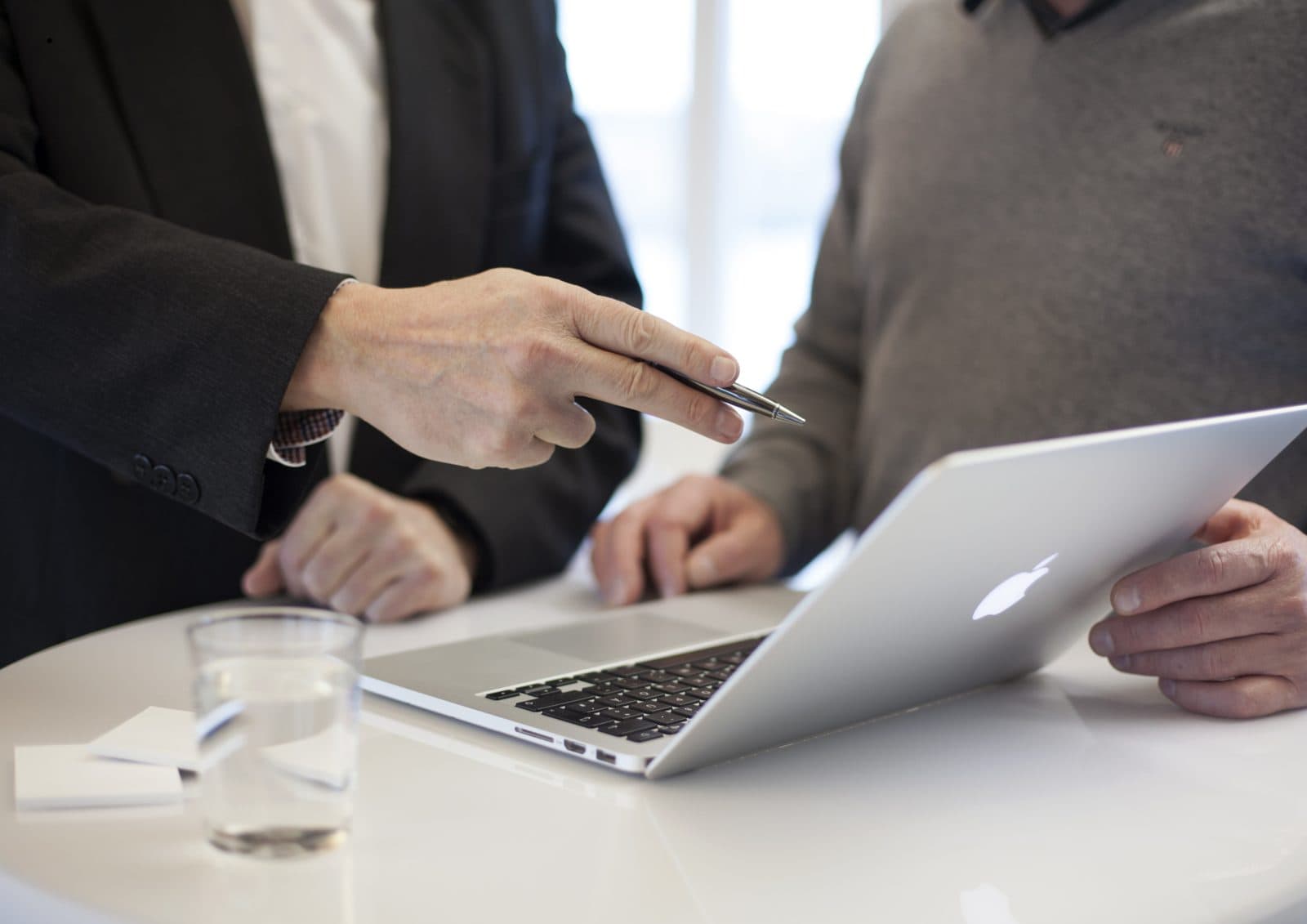 Officials reviewing project documents beside a laptop