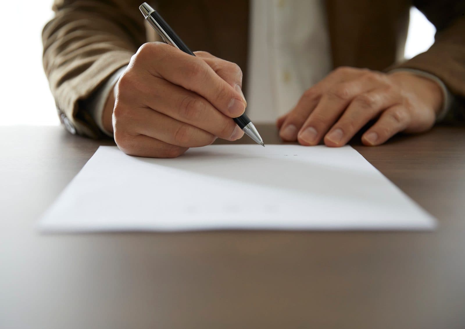Hand signing an official notice document with a pen