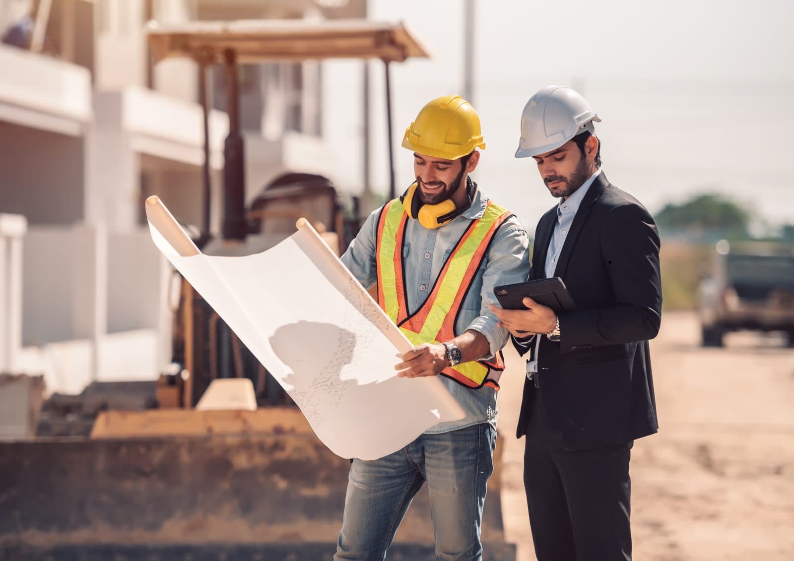 Contractor and inspector reviewing plans together at a construction site