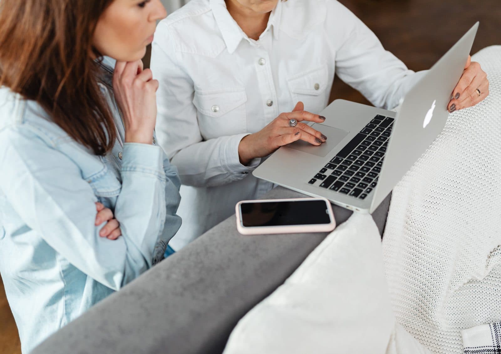 Two colleagues reviewing information together on a laptop