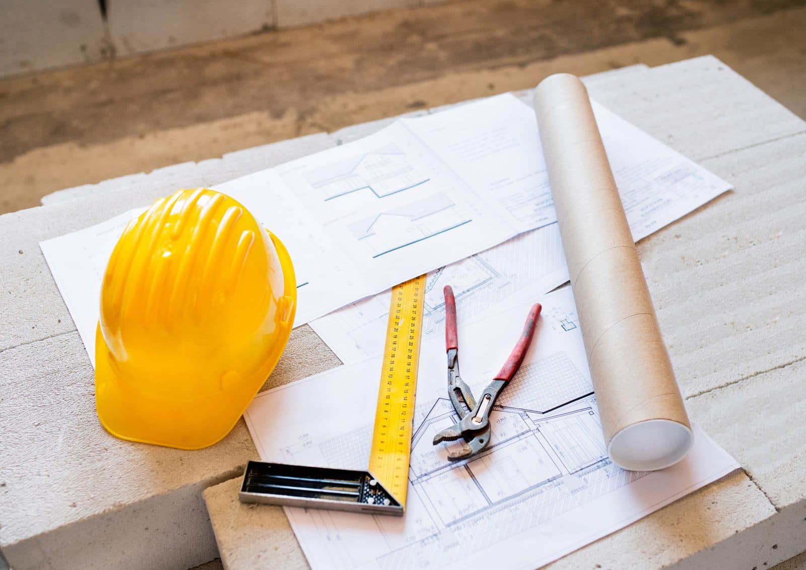 Yellow hard hat and measuring tools resting on construction plans