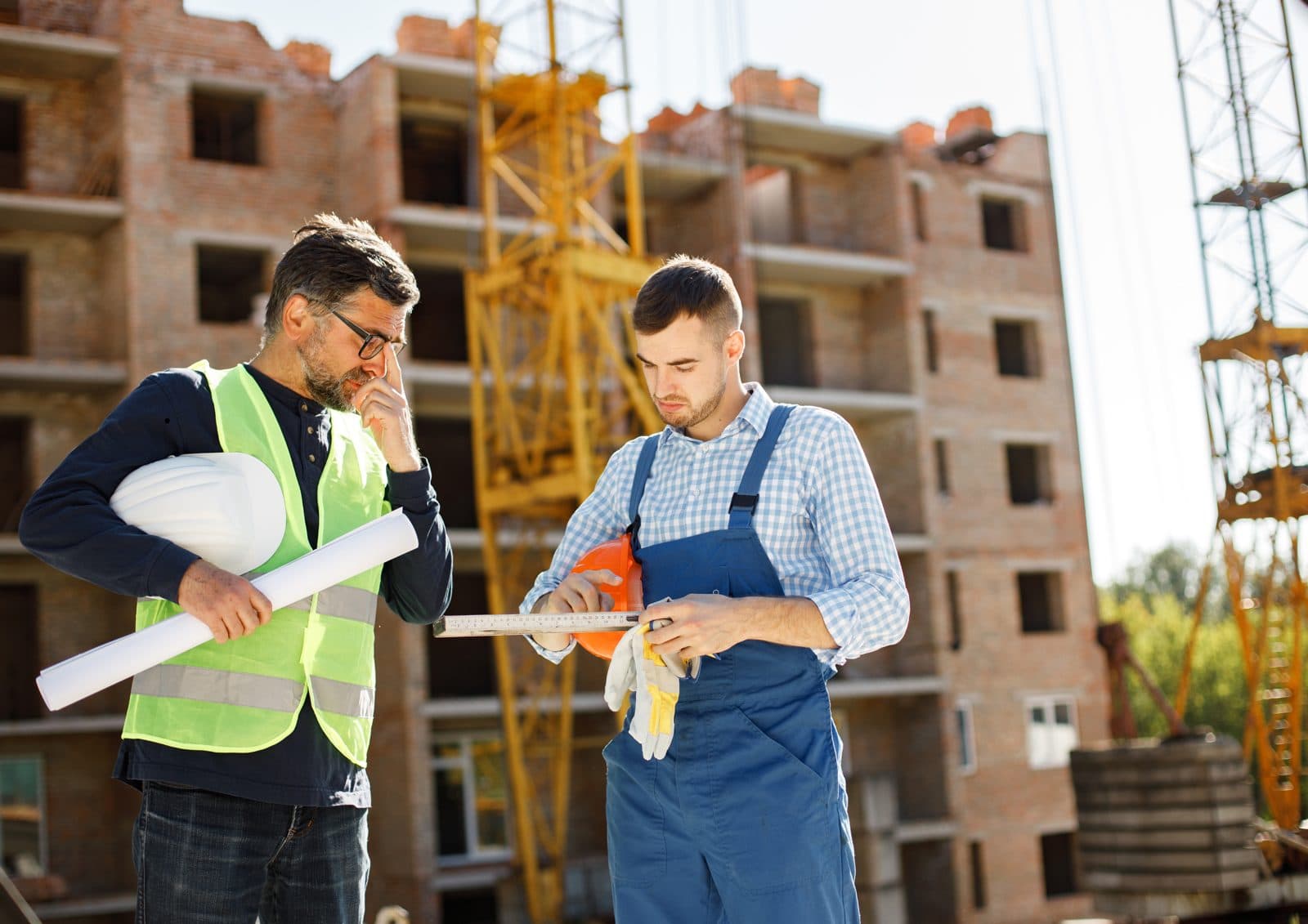 Two construction professionals reviewing plans at a building site