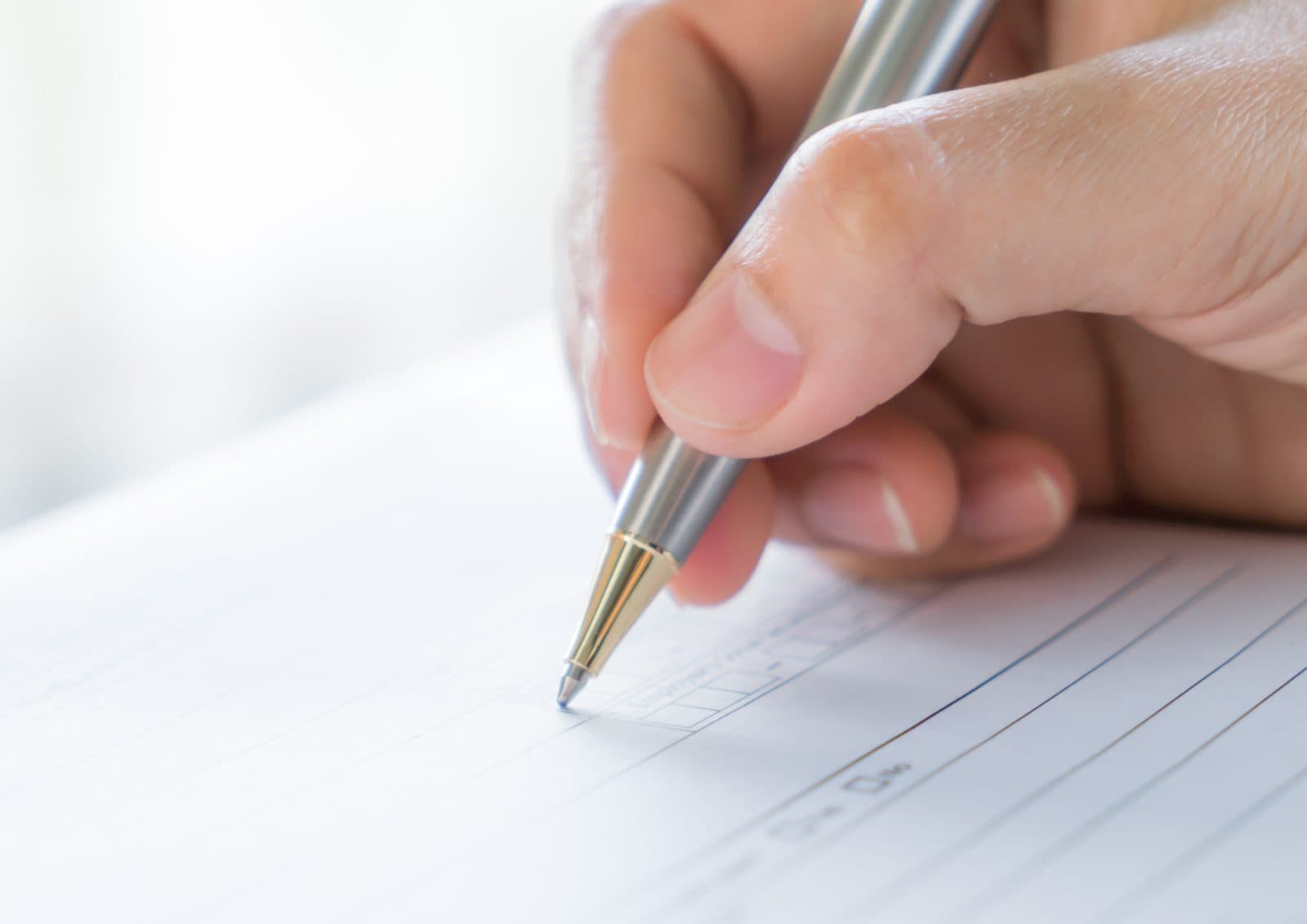 Hand completing an official form with a pen