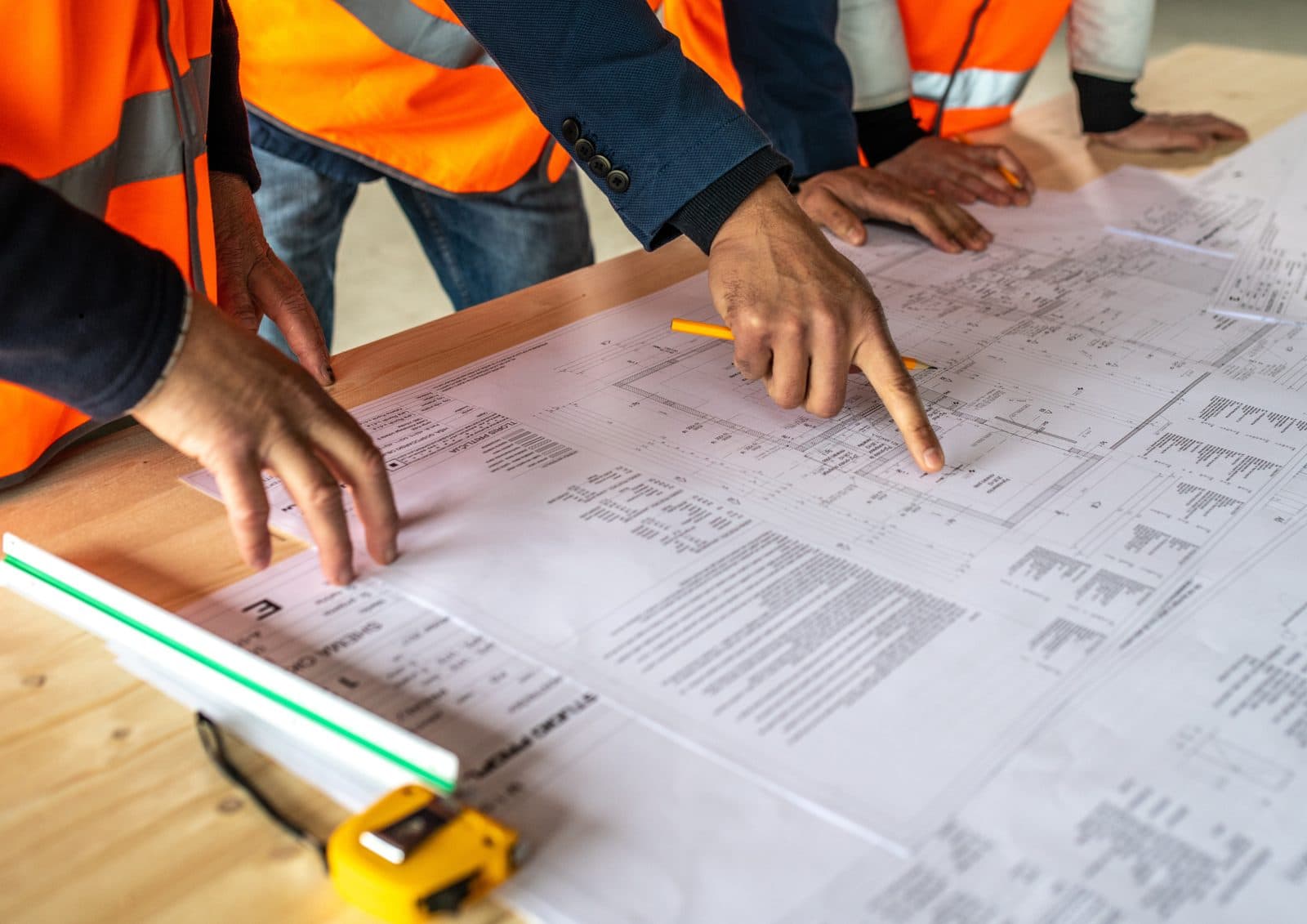 Hands pointing at construction drawings during a plan review